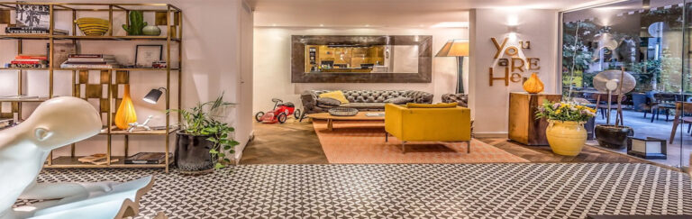 הלובי המעוצב ב- מלון שינקין תל אביב עם כורסאות שטיחים ושלל ספרים