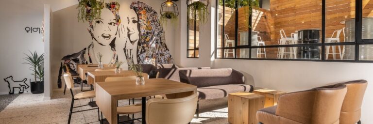 איזור לאונג' הקפה ב-הוטל 75 תל אביב מאובזר כורסאות שולחנות וציור קיר גדול